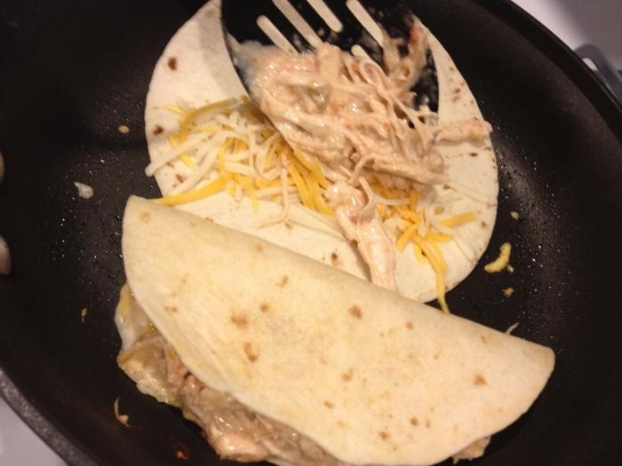 flat cakes in a frying pan with cheese