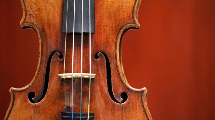 How many strings does a violin have and how does the instrument work?
